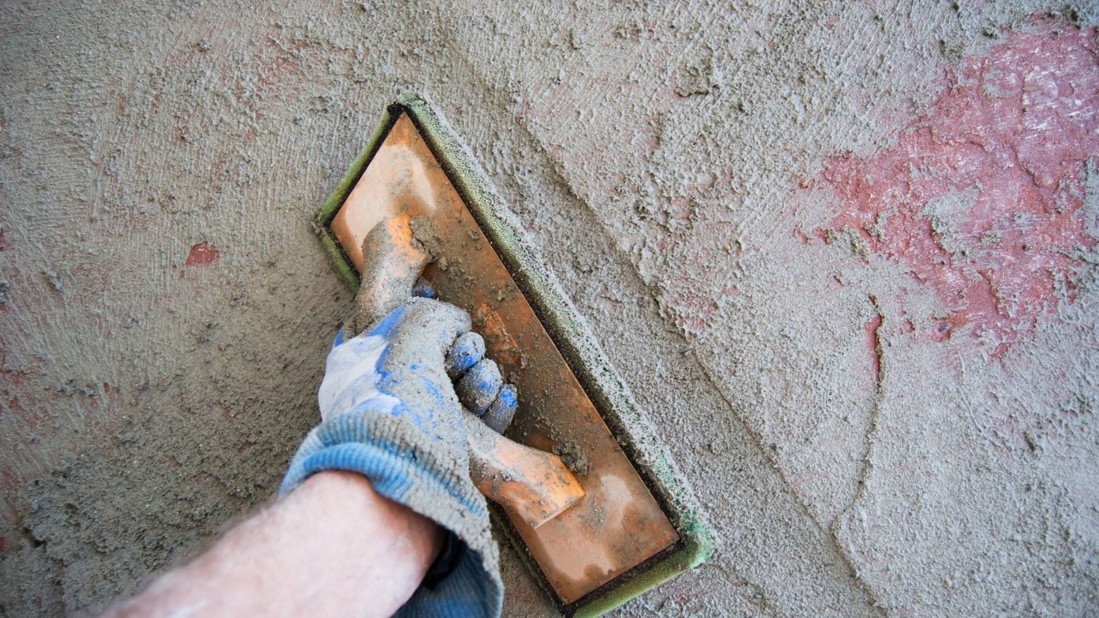 Technician smoothing freshly applied grout with a trowel.