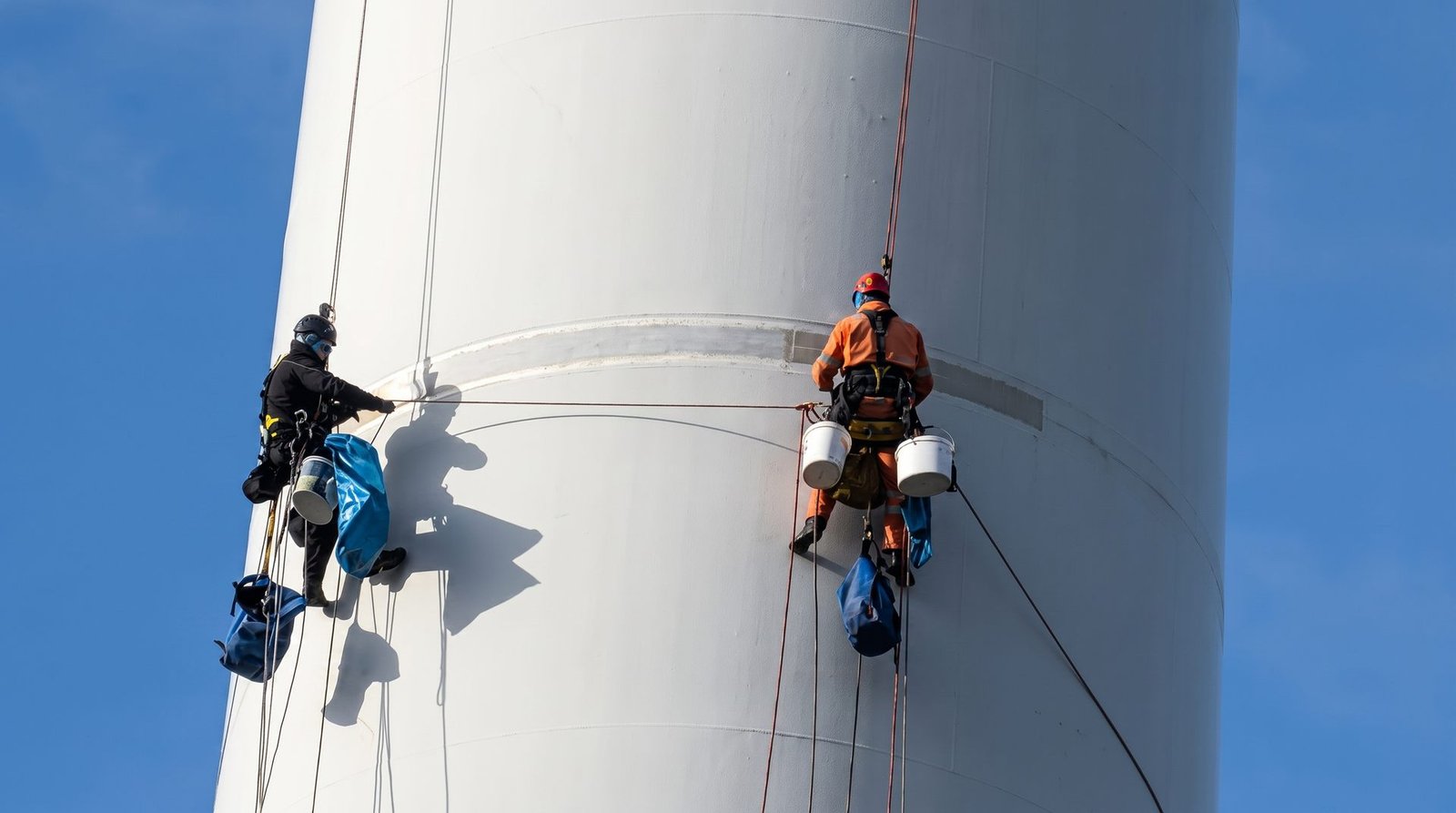 Rope access technicians working on a wind turbine tower.